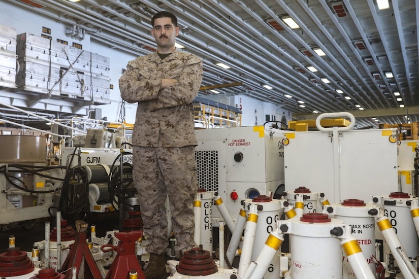 Marine Corps Lance Cpl. Andre Pedro poses for a photo in the hangar bay aboard the amphibious assault ship USS Bataan, Jan. 26, 2017. Pedro works in the ground support division, which is responsible for fixing, maintaining and tracking all the equipment used to work on aircraft. The ship is currently deployed with the Bataan Amphibious Ready Group in the U.S. 5th Fleet area of operations in support of maritime security operations designed to reassure allies and partners, and preserve the freedom of navigation and the free flow of commerce in the region. Navy photo by Petty Officer 3rd Class Raymond Minami