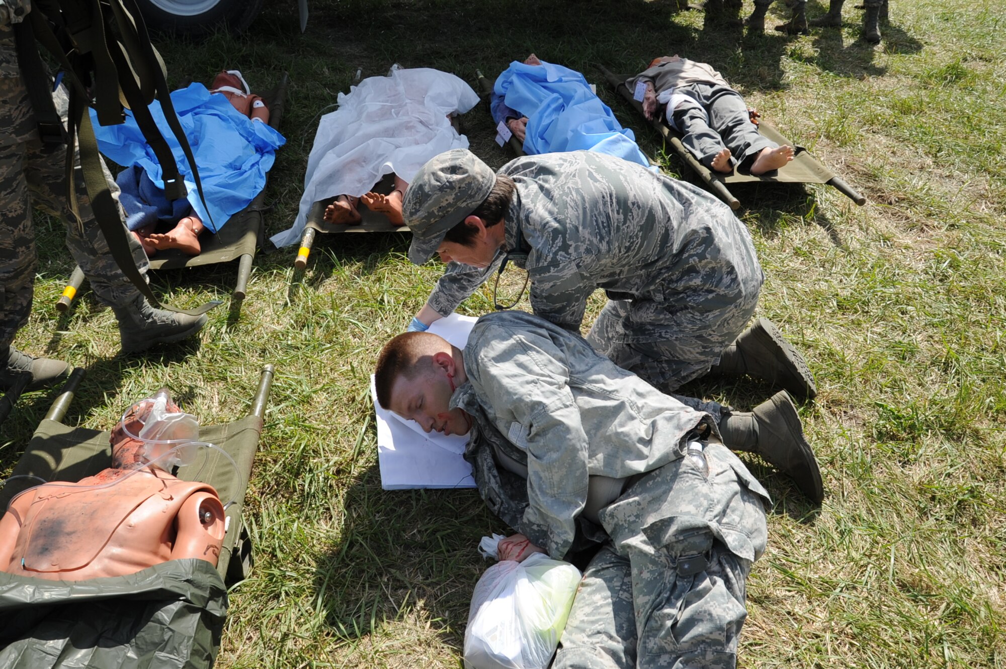 Lt. Col. Candy Wilson, 779th Medical Group chief nurse, sets a pillow under the head of an actor posing as a patient injured April 26, 2017 at Camp Atterbury, Ind. The actor portrayed a patient suffering from a head injury and body lacerations resulting from a mock nuclear attack that occurred within the U.S. (U.S. Air Force photo by Staff Sgt. Joe Yanik)