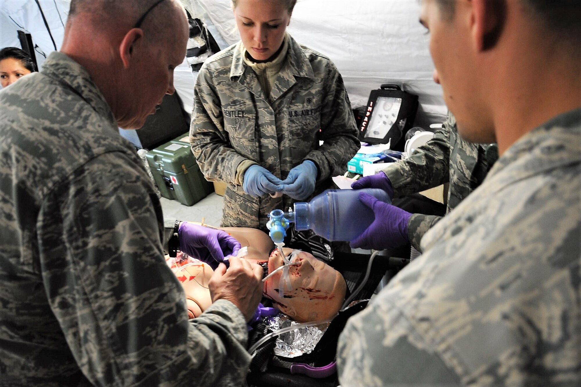 Maj. Richard Odosso (left) 779th Medical Group nurse, adjusts the air tubes inserted into a dummy portraying a wounded patient at the group's Emergency Medical Support facility April 28, 2017 at Camp Atterbury, Ind. Unlike civilian nurses, military nurses like Odosso are trained to treat patients during aeromedical evacuation missions and in deployed settings. (U..S. Air Force photo by Staff Sgt. Joe Yanik)