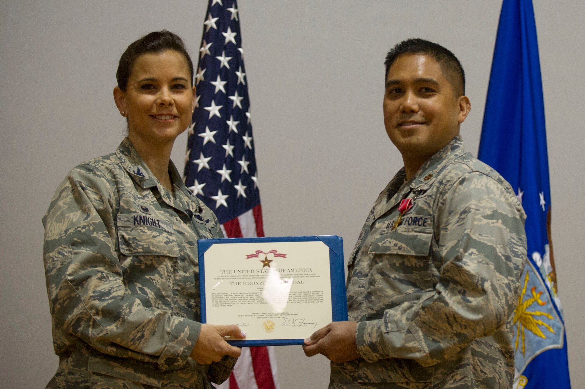 Col. Leslie Knight, 779th Medical Group commander, and recent Bronze Star recipient Maj. Dino Quijano, a critical care nurse, display Maj. Quijano’s citation. The Air Force is recognizing the contributions of nurses and medical technicians during National Nurses and Technicians week. (Photo by Senior Master Sgt. Adrian Cadiz)(Released)