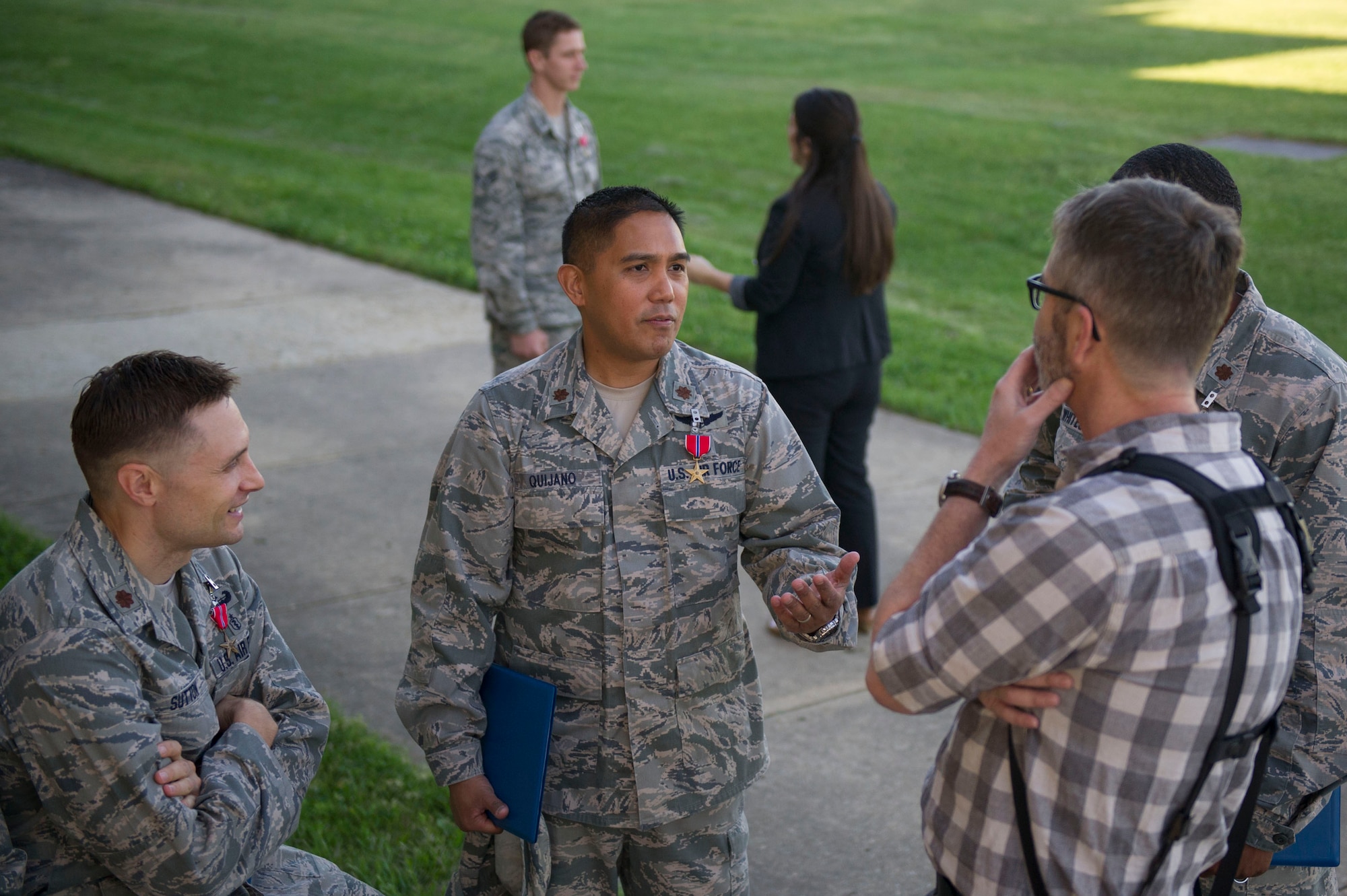 Maj. Noah Sutton (left) and Maj. Dino Quijano (center),  both of the 779th Medical Group, speak with a photojournalist from Airman Magazine as they are interviewed after being awarded a Bronze Star Medal during a commander's call at Joint Base Andrews, Md., May 3, 2017.  (Photo by Senior Master Sgt. Adrian Cadiz)(Released)