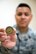 U.S. Air Force Airman 1st Class EJ Kevin Sto. Domingo, 60th Diagnostics and Therapeutics Squadron, Travis Air Force Base, Calif., holds up the chief coin that was given to him by Chief Master Sgt. Shelina Frey, command chief Air Mobility Command, May 9, 2017. Frey was given the coin as an airman by a chief and vowed to pass it on when she recognized a young airman with leadership potential. (U.S. Air Force photo by Louis Briscese)