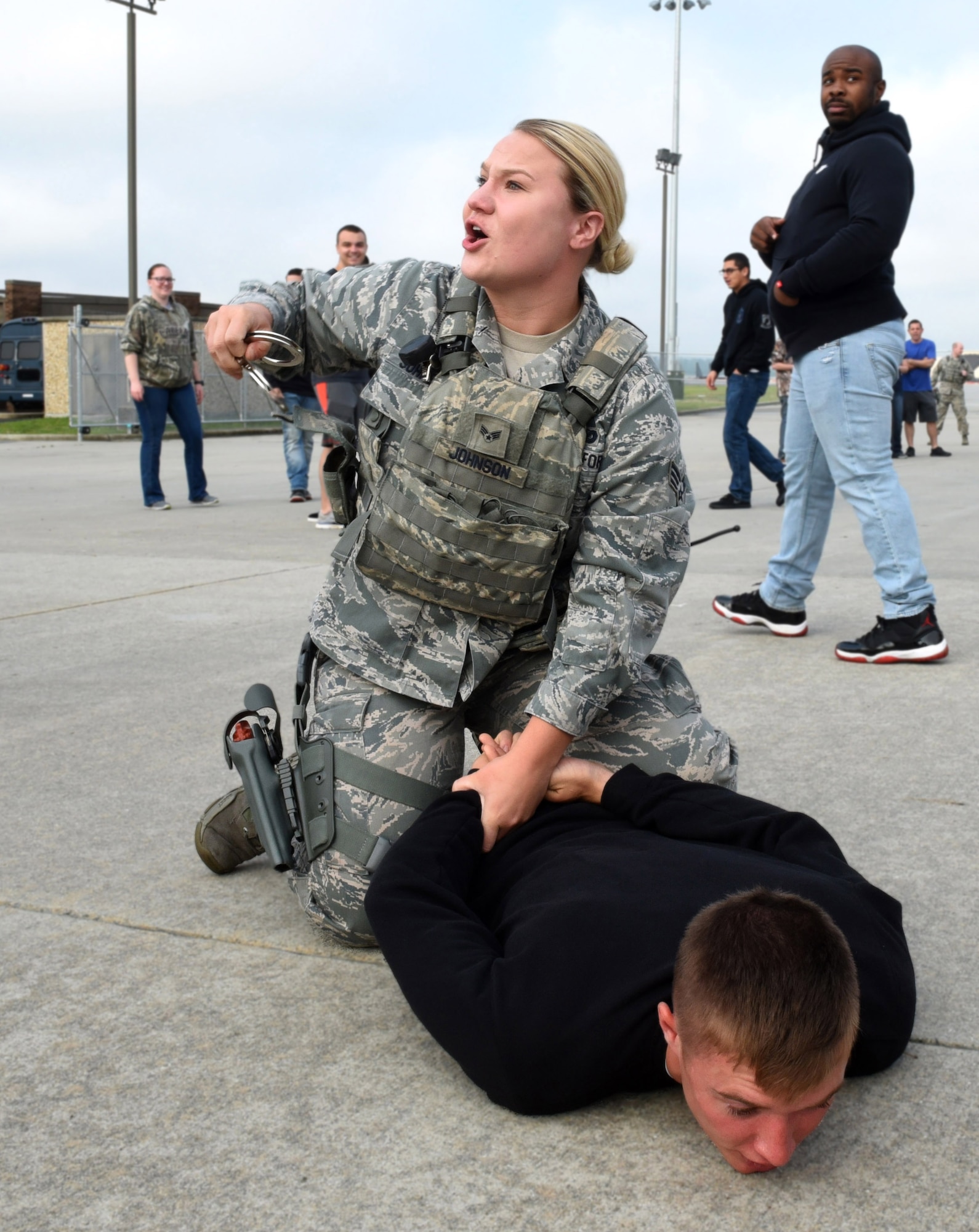 Senior Airman Paige E. Johnson, 4th Security Forces Squadron patrolman, apprehends simulated stabbing suspect, Senior Airman Alexander Ritsema, 4th Maintenance Group weapons standardization technician, as another participant prepares to detonate a simulated bomb vest, during a Major Accident Response Exercise, May 10, 2017, at Seymour Johnson Air Force Base, North Carolina. During the exercise members from the 4th Security Forces Squadron detained the suspect, evacuated the scene and set up a perimeter around the area. (U.S. Air Force photo by Airman 1st Class Victoria Boyton)