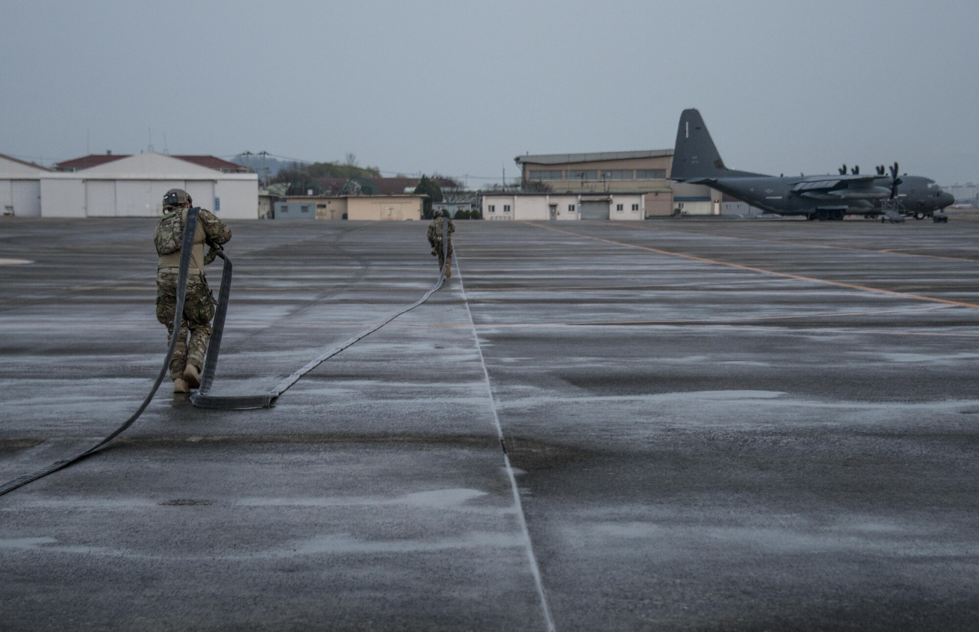 U.S. Air Force 18th Logistics Readiness Squadron forward area refueling point (FARP) technicians transport a refueling hose from a U.S. Air Force MC-130J Commando II assigned to the 17th Special Operations Squadron during a FARP operation, April 1, 2017 at Daegu Air Base, Republic of Korea. The FARP team refueled a U.S. Army MH-47G Chinook assigned to the 160th Special Operations Aviation Regiment during exercise Foal Eagle 2017. (U.S. Air Force photo by Capt. Jessica Tait)