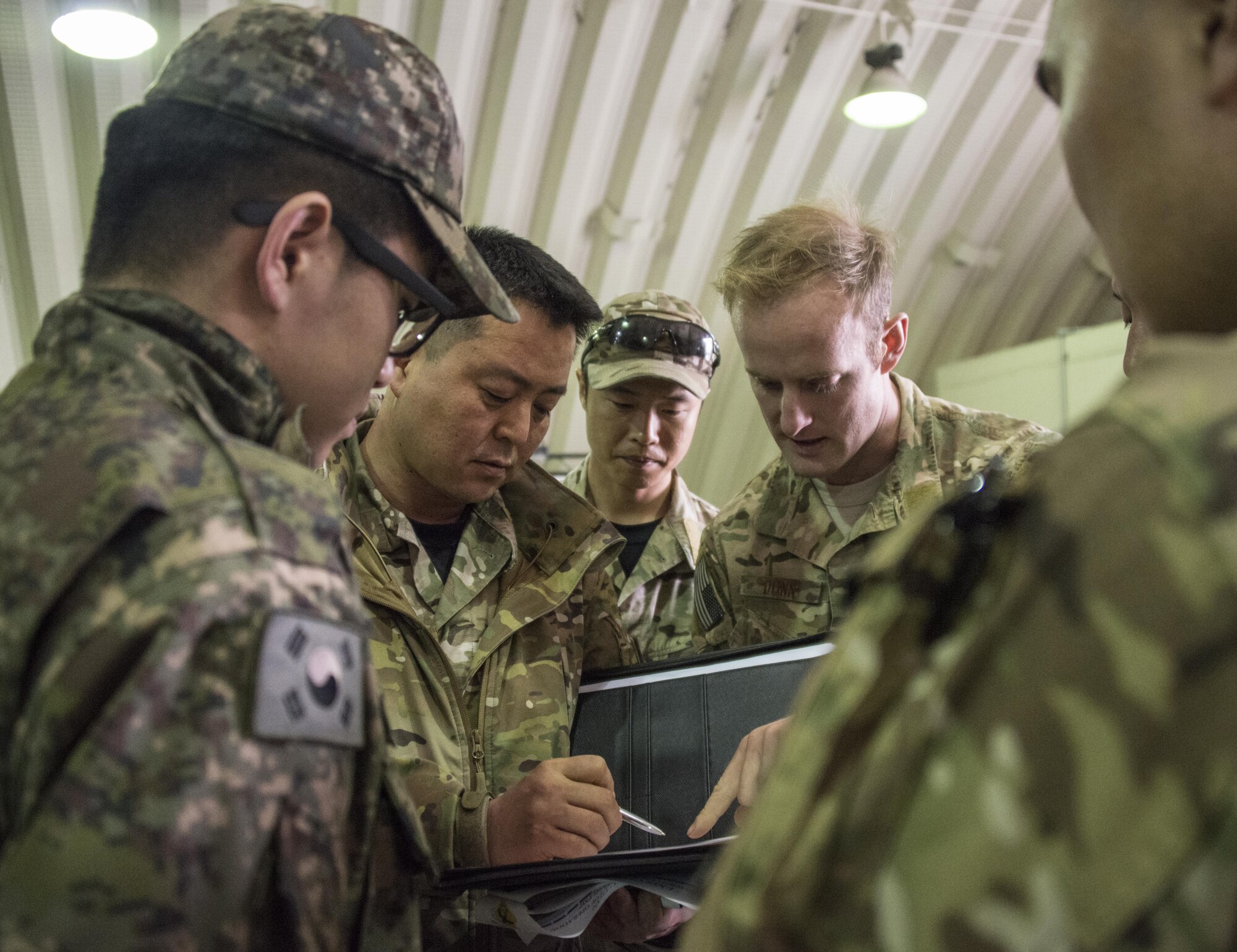 A U.S. Air Force 320th Special Tactics Squadron special tactics officer engages with his counterparts from the Republic of Korea 255th Special Operations Squadron during a discussion on military free fall operations, March 24, 2017 at Daegu Air Base, ROK. Foal Eagle 2017 provided an opportunity for the 320th STS to advance interoperability and increase partner capacity by planning and executing complex training missions with multiple joint and combined units. (U.S. Air Force photo by Capt. Jessica Tait)