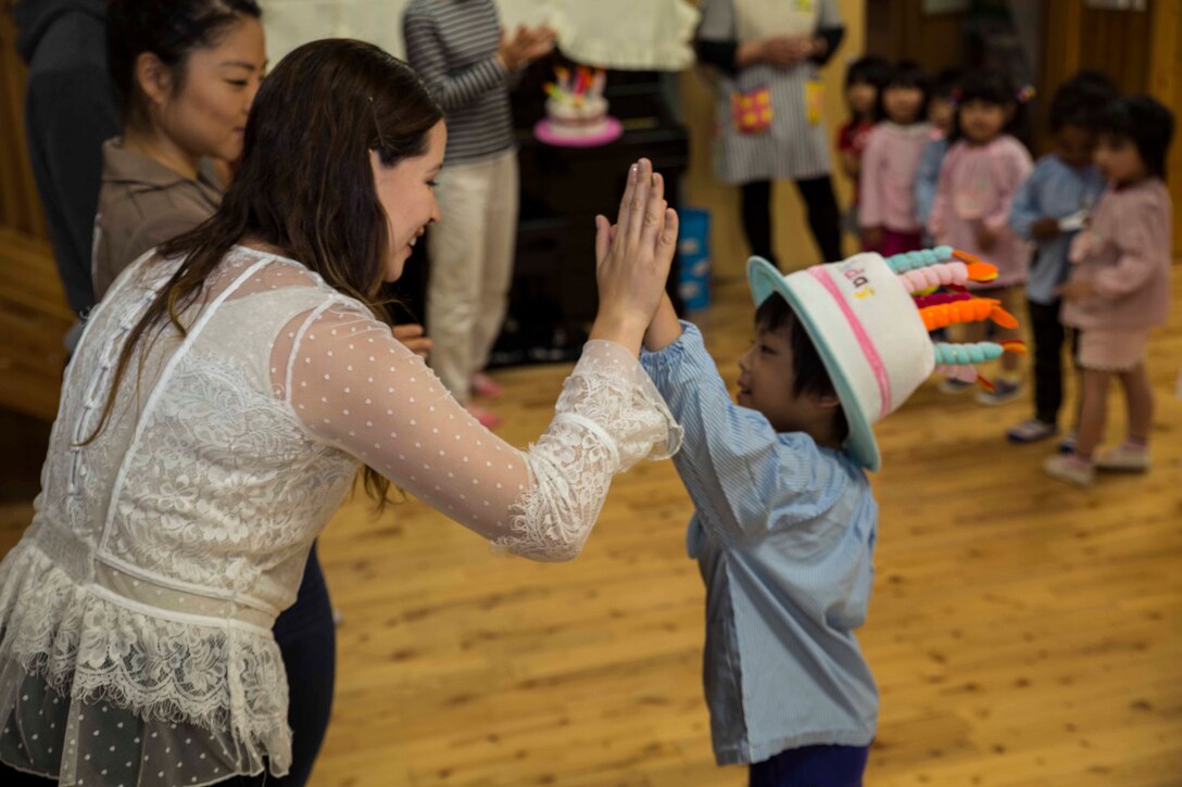 Michelle Hena, a volunteer with the Marine Memorial Chapel, high-fives a Josho Hoikuen Preschool student after singing “Happy Birthday” to him during a community relations event in Iwakuni City, Japan, May 9, 2017. Volunteering at the preschool helped the relationship between Marine Corps Air Station  Iwakuni residents and the local community grow stronger. Introductions were given by the volunteers while students asked them questions, then the children were introduced to “The Hokey Pokey” and “Head, Shoulders, Knees and Toes” before playing educational games with the volunteers. (U.S. Marine Corps photo by Lance Cpl. Gabriela Garcia-Herrera)