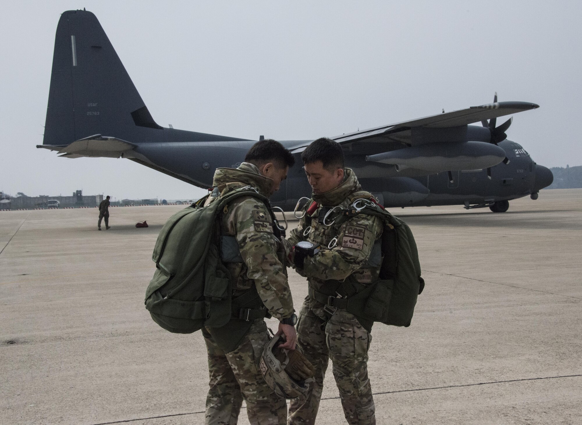 Republic of Korea 255th Special Operations Squadron combat controllers prepare their parachute equipment prior to boarding a U.S. Air Force MC-130J Commando II assigned to the 17th Special Operations Squadron, March 25, 2017 at Kunsan Air Base, ROK. Foal Eagle 2017 provided the opportunity at further developing interoperability with counterparts from the ROK military through daily airborne operations to include military free fall and static line drops. (U.S. Air Force photo by Capt. Jessica Tait)