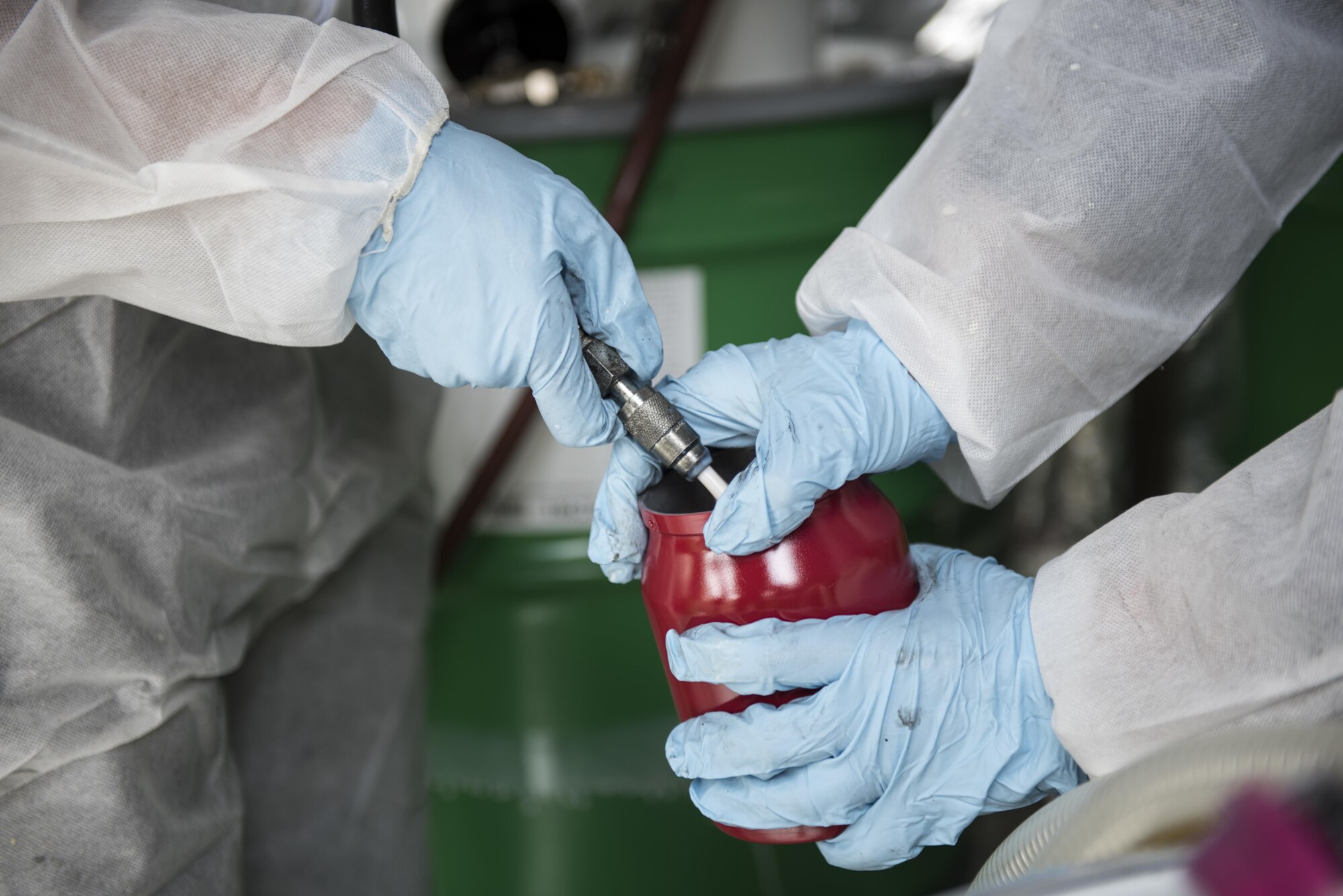 U.S. Air Force Airmen from the 18th Logistics Readiness Squadron fill a container with a corrosion control substance April 6, 2017, at Kadena Air Base, Japan. The 18 LRS’s new vehicle corrosion control could possibly save the U.S. Air Force millions of dollars by preventing or minimizing the effects the corrosion on equipment in corrosive climates.  (U.S. Air Force photo by Senior Airman Omari Bernard)