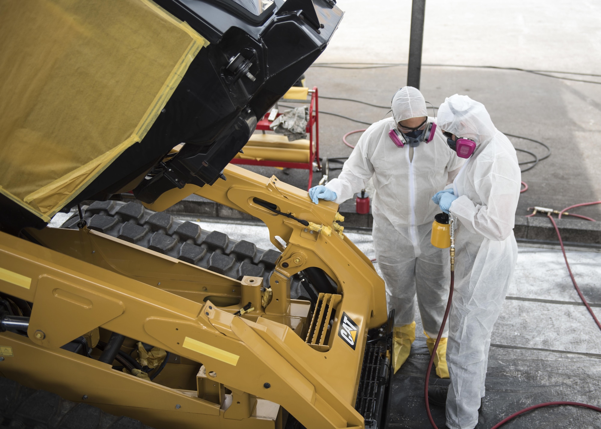 U.S. Air Force Airmen from the 18th Logistics Readiness Squadron prepare canisters of anti-corrosion chemicals April 6, 2017, at Kadena Air Base, Japan. The new anti-corrosion chemicals extend the serviceability of the 18th LRS’s air field damage repair vehicle fleet by an estimated five to 10 years. (U.S. Air Force photo by Senior Airman Omari Bernard)