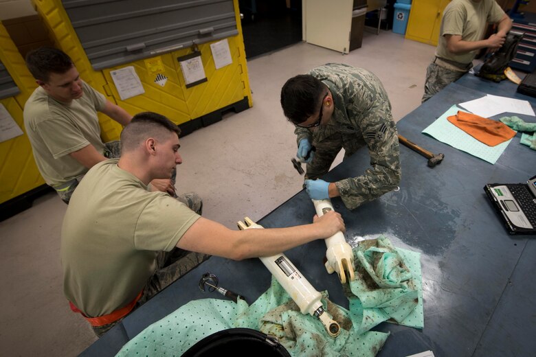 U.S. Air Force hydraulics technicians from the 18th Component Maintenance Squadron hydraulics back shop assemble an F-15 Eagle landing gear actuator May 2, 2017, at Kadena Air Base, Japan. Hydraulics Airmen's responsibilities include maintaining the hydraulic systems of all Kadena Aircraft which allow the aircraft to steer, land and ultimately support Airmen on the battlefield. (U.S. Air Force photo by Senior Airman John Linzmeier)