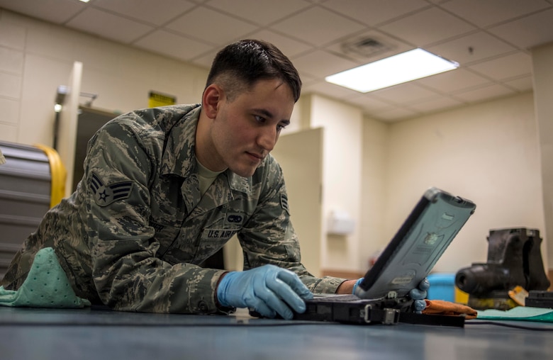 U.S. Air Force Senior Airman Adam Fischer, 18th Component Maintenance Squadron hydraulics technician, refers to his technical orders while servicing aircraft components May 2, 2017, at Kadena Air Base, Japan. Technical orders are step-by-step instruction manuals used by maintenance Airmen that list proper tools needed, any hazards to be aware of and protective gear to accomplish the task. (U.S. Air Force photo by Senior Airman John Linzmeier)