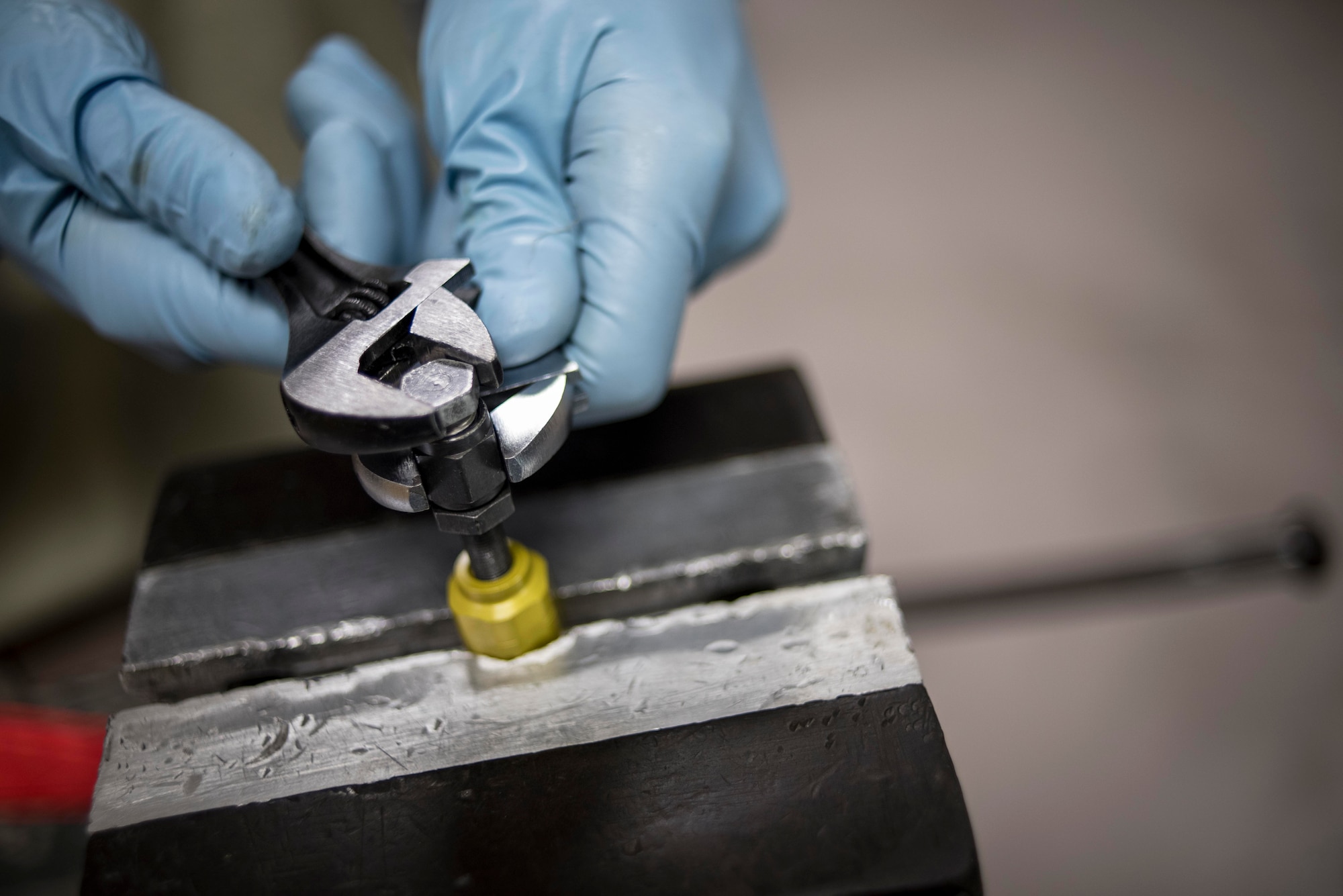 U.S. Air Force Senior Airman Joshua Cox, 18th Component Maintenance Squadron hydraulics technician, tightens a medium pressure rubber hose assembly May 2, 2017, at Kadena Air Base, Japan. Hydraulics Airmen often rely on several shifts in order to complete repairs in a timely fashion, such as having one shift disassembling and inspecting a part and the next shift reassembling and testing the part. (U.S. Air Force photo by Senior Airman John Linzmeier)
