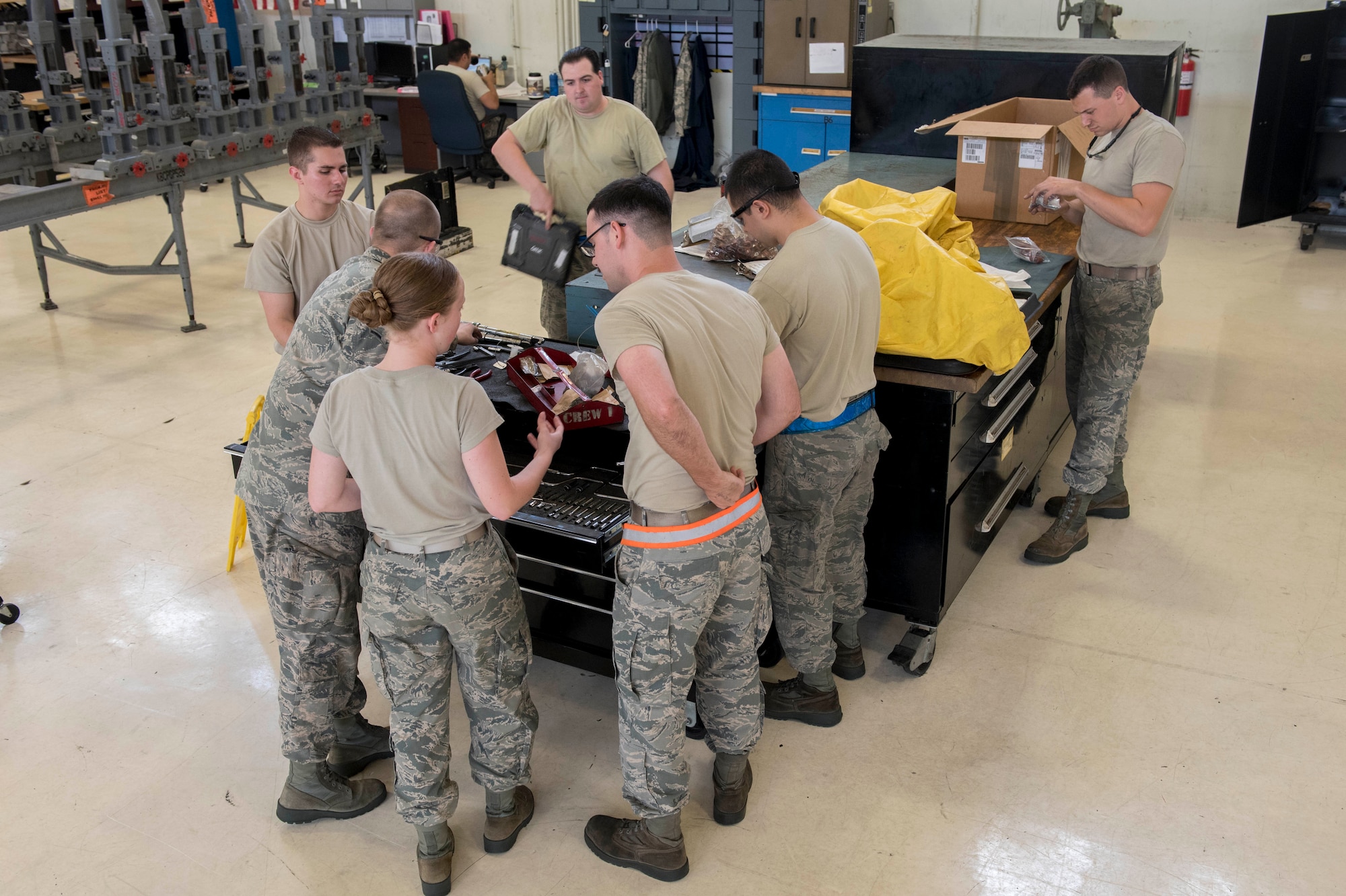 A team of aerospace propulsion technicians from the 18th Component Maintenance Squadron gather around a workbench May 12, 2017, at Kadena Air Base, Japan. The Airmen worked together to prepare an F-15 Eagle engine for a trial run at the test cell. (U.S. Air Force photo by Senior Airman John Linzmeier)