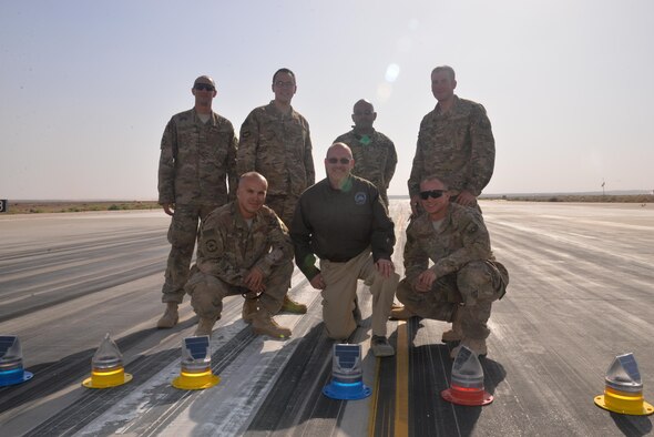 Members from the 332nd Expeditionary Civil Engineer Squadron pose with solar lights on the flight line, May 10th, 2017, in Southwest Asia.  The 332nd ECES installed solar lights on the flight line, making it safer for pilots during night operations. (U.S. Air Force Photo by Staff Sgt. Samuel O’Brien)