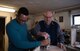Retired Chief Master Sgt. Charles E. Milam shows Airman 1st Class Timmethy James, 86th Airlift Wing Public Affairs broadcaster, how to properly edge a piece of wood in his workshop in Waldfischbach-Burgalben, Germany, May 2, 2017.  During his 30 years of active-duty service, Milam was awarded the Bronze Star for his valor and meritorious service while he had administrative supervision over 11 Airmen assigned to security for the Presidential Advisor on Vietnam Affairs. He also trained Vietnamese guards who provided security for the embassy housing during his second Vietnam tour. (U.S. Air Force photo by Airman 1st Class Savannah L. Waters)