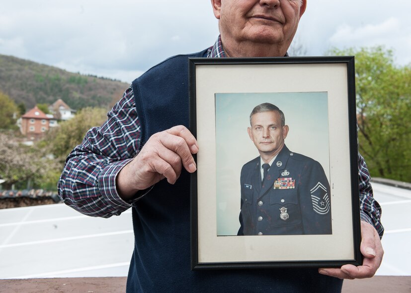 Retired Chief Master Sgt. Charles E. Milam poses with a photo of himself at his house in Waldfischbach-Burgalben, Germany, May 2, 2017. Milam, born in Lakeland, Fla., served in the U.S. Air Force from 1955 to 1985. (U.S. Air Force photo by Airman 1st Class Savannah L. Waters)