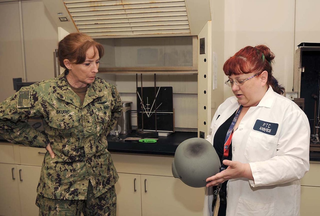 DLA Land and Maritime Commander Navy Rear Adm. Michelle Skubic (left) discusses the results of blunt force impact testing for helments with DLA Mechanicsburg lab technician Sally Schuster  during a site visit.