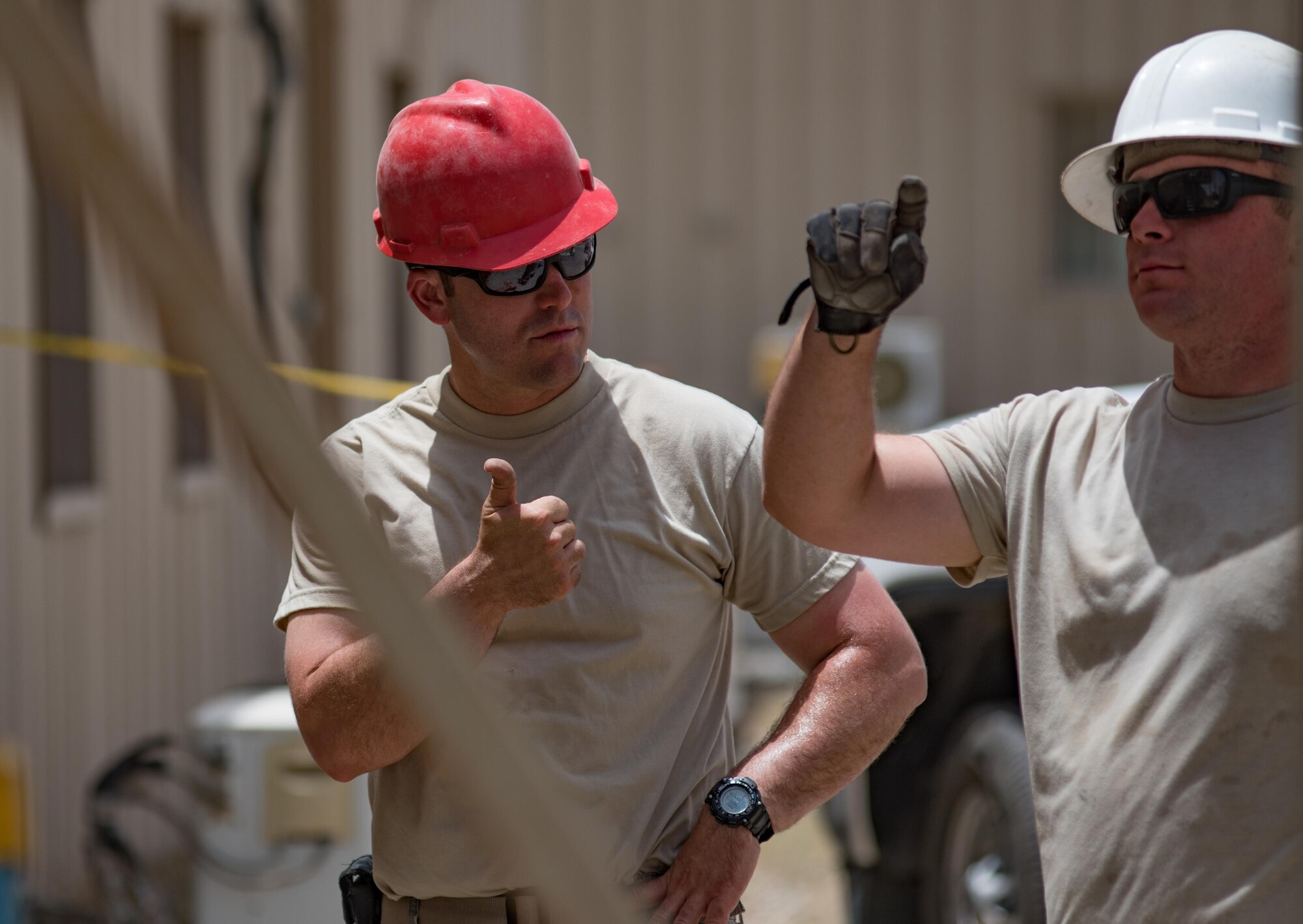Tech. Sgt. Travis Monks, left, a heating, ventilation and air conditioning technician and NCO in charge of HVAC installs with the 407th Expeditionary Civil Engineer Squadron, signals the “thumbs-up” to Staff Sgt. Matthew Sayward, a pavement equipment operator with the407th ECES , during the installation of an industrial air conditioning unit May 4, 2017, in Southwest Asia. The new cooling system will provide cooled air to an operations building at the 407th Air Expeditionary Group in time for the significant rise of summer temperatures in the region. Marines and Airmen frequently partner to sharpen joint skillsets and complete pressing work assignments. Monks is member of the Air Force Reserve and deployed from March Air Reserve Base, Calif. (U.S. Air Force photo by Staff Sgt. Alexander W. Riedel)