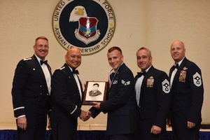 Col. Robert Lyman, left, 628th Air Base Wing commander, Col. Jimmy Canlas, second to left, 437th Airlift Wing commander, Chief Master Sgt. Kristopher Berg, second to right, 437th AW command chief, Chief Master Sgt. Todd Cole, right, 628th ABW command chief, congratulate Senior Airman Ethan Anderson, middle, 437th Aerial Port Squadron information controller, for earning the John L. Levitow Award during the class 17-D Airman Leadership School Graduation ceremony at Joint Base Charleston, S.C. May 11, 2017. The Levitow Award is the highest honor awarded to an ALS graduate and is given to the Airman who displays the highest level of leadership qualities. ALS is a five-week course encompassing lessons in the principles of supervision and management, the importance of communication and military professionalism.