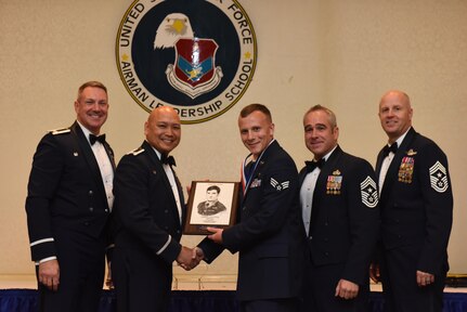 Col. Robert Lyman, left, 628th Air Base Wing commander, Col. Jimmy Canlas, second to left, 437th Airlift Wing commander, Chief Master Sgt. Kristopher Berg, second to right, 437th AW command chief, Chief Master Sgt. Todd Cole, right, 628th ABW command chief, congratulate Senior Airman Ethan Anderson, middle, 437th Aerial Port Squadron information controller, for earning the John L. Levitow Award during the class 17-D Airman Leadership School Graduation ceremony at Joint Base Charleston, S.C. May 11, 2017. The Levitow Award is the highest honor awarded to an ALS graduate and is given to the Airman who displays the highest level of leadership qualities. ALS is a five-week course encompassing lessons in the principles of supervision and management, the importance of communication and military professionalism.
