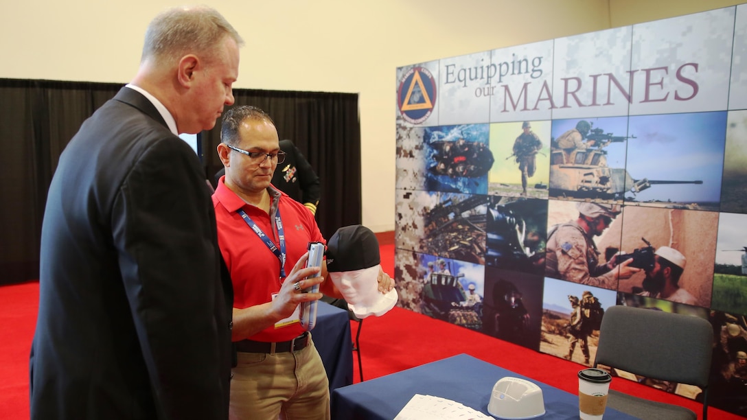 Mark Urrutic, project officer for Family of Field Medical Equipment Team at Marine Corps Systems Command, uses an Infrascanner to locate a simulated hematoma on a mannequin's skull while MCSC's Executive Director William Williford looks on at the Navy League's Sea Air Space Exhibition in National Harbor, Maryland, on April 3. The Infrascanner is a portable, medical diagnostic device that provides early detection of intracranial hematomas-or bleeding within the skull-in the field, potentially saving lives and improving casualty care and recovery.