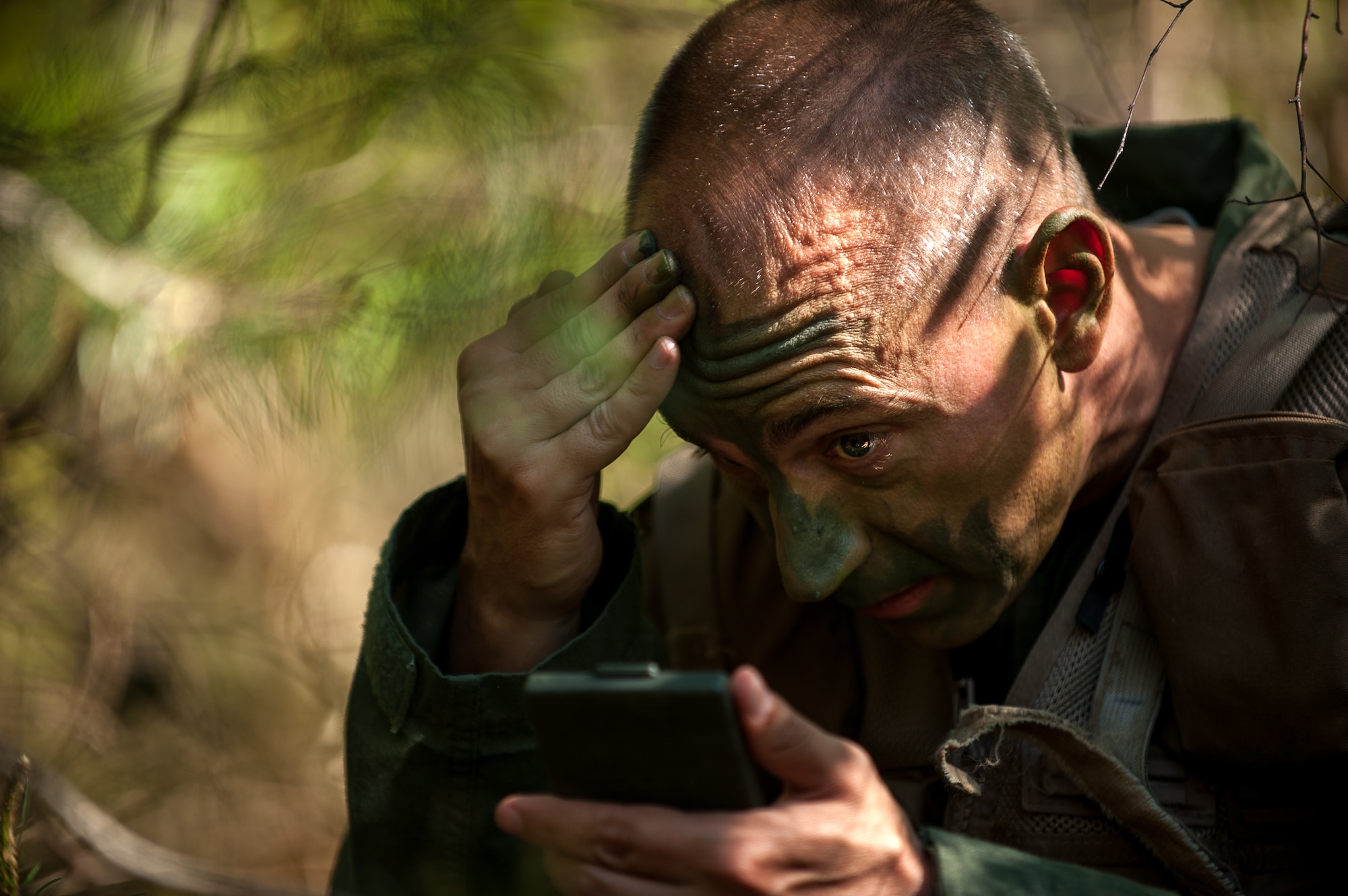 U.S. Air Force Col. Andrew Purath, senior developmental student, applies camouflage face paint to his forehead during Survival Evasion Resistance and Escape training on Rhine Ordinance Barracks, Germany, May 10, 2017. Purath and other aircrew members trekked through the woods to simulate being isolated in a combat environment. (U.S. Air Force photo by Senior Airman Devin Boyer/Released)
