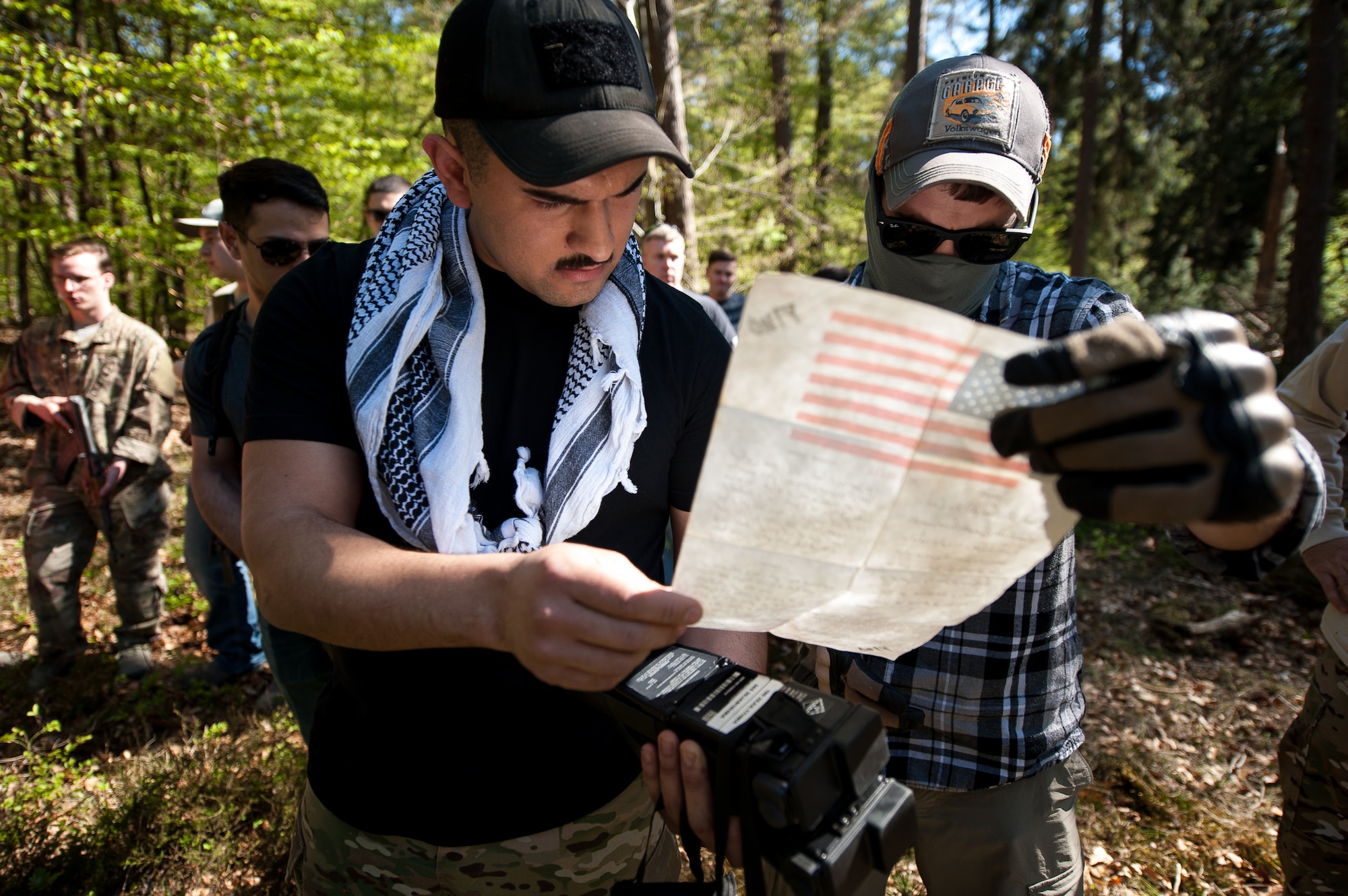 U.S. Air Force Senior Airman Eric Contreras and Staff Sgt. Kyle Helms, Survival Evasion Resistance and Escape augmenters, read over a blood chit during SERE training on Rhine Ordinance Barracks, Germany, May 10, 2017. A blood chit is a notice carried by military personnel and addressed to any civilians who may come across an armed-services member, such as a downed pilot. (U.S. Air Force photo by Senior Airman Devin Boyer/Released)