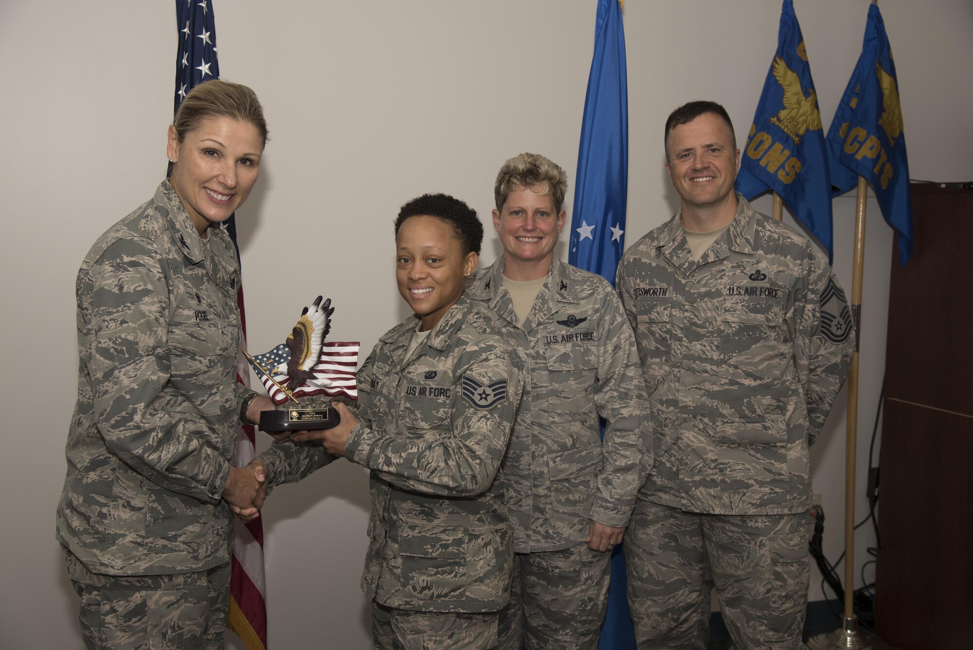 Col. April Vogel, commander of the 6th Air Mobility Wing, presents Staff Sgt. Nia Holloway, contract specialist assigned to the 6th Contracting Squadron, with an award for being named Air Mobility Command and Air Force’s 2016 Outstanding Contracting Enlisted Member of the Year May 11, 2017, at MacDill Air Force Base, Fla. Holloway received these awards for her outstanding performance as a contract specialist during the year of 2016. (U.S. Air Force photo by Airman 1st Class Adam R. Shanks) 