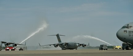 A C-17 Globemaster III moves through a water salute after completing a “fini” flight for Chief Master Sgt. Kristopher Berg, 437th Airlift Wing command chief, at Joint Base Charleston, S.C., May 11, 2017. Berg’s wife Amy, his 8 year old daughter Bella, Airmen and civilians were present to congratulate him during the event. The flight was part of a real world mission. 