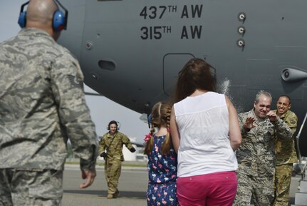 Chief Master Sgt. Kristopher Berg, 437th Airlift Wing command chief, is sprayed down with water by his wife, Amy, and 8 year old daughter, Bella, during his final flight at Joint Base Charleston, S.C., May 11, 2017. Airmen and civilians were present to congratulate him during the event. 