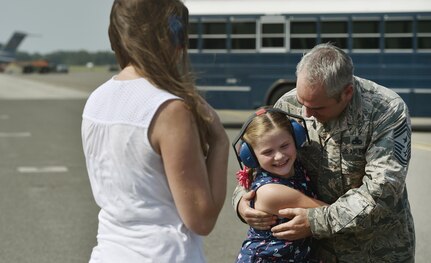 Chief Master Sgt. Kristopher Berg, right, 437th Airlift Wing command chief, hugs his 8 year old daughter, Bella, during his final flight at Joint Base Charleston, S.C., May 11, 2017. His wife, Amy, left, Airmen and civilians were present to congratulate him during the event. 