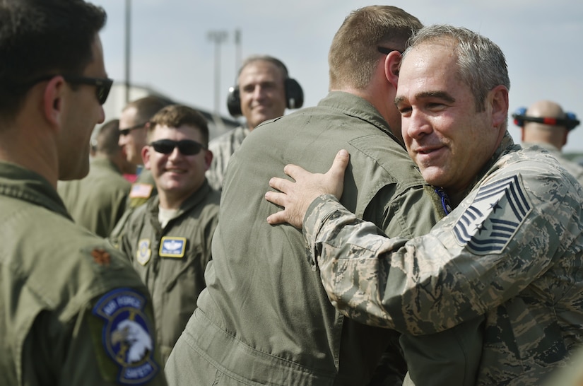 Chief Master Sgt. Kristopher Berg, right, 437th Airlift Wing command chief is congratulated by Airmen during his final flight at Joint Base Charleston, S.C., May 11, 2017. His wife, Amy, 8 year old daughter, Bella, Airmen and civilians were present to congratulate him during the event.