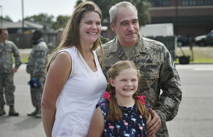 Chief Master Sgt. Kristopher Berg, right, 437th Airlift Wing command chief, poses for a photo with his wife, Amy, left, and 8 year old daughter, Bella, center, during his final flight at Joint Base Charleston, S.C., May 11, 2017. Airmen and civilians were also present to congratulate him during the event. (U.S. Air Force photo by Staff Sgt. Christopher Hubenthal)