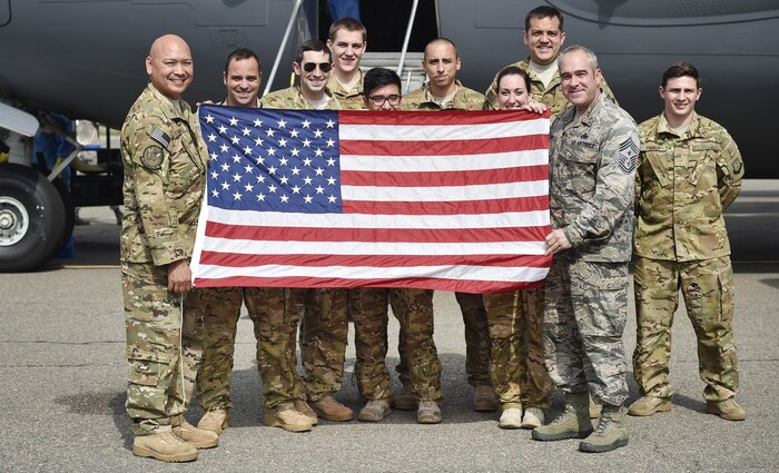 Chief Master Sgt. Kristopher Berg, right, 437th Airlift Wing command chief, poses for a photo with Col. Jimmy Canlas, 437th AW commander, and Airmen of the 437th AW during his final flight at Joint Base Charleston, S.C., May 11, 2017. His wife, Amy, 8 year old daughter, Bella, Airmen and civilians were also present to congratulate him during the event. 