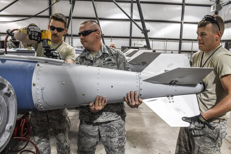 From the left, Senior Airman Steven Woods, Tech. Sgt. Joseph Munis and Senior Airman Zane Sitzes, all active-duty Airmen from the 301st Fighter Wing, Naval Air Station Fort Worth Joint Reserve Base, Texas, build GBU-31 bombs April 26 at Hill Air Force Base, Utah. The 301st FW sent Airmen and F-16 Fighting Falcon aircraft to Hill AFB for Combat Hammer, an air-to-ground weapons evaluation exercise conducted by the 86th Fighter Weapons Squadron.  (U.S. Air Force/Paul Holcomb)