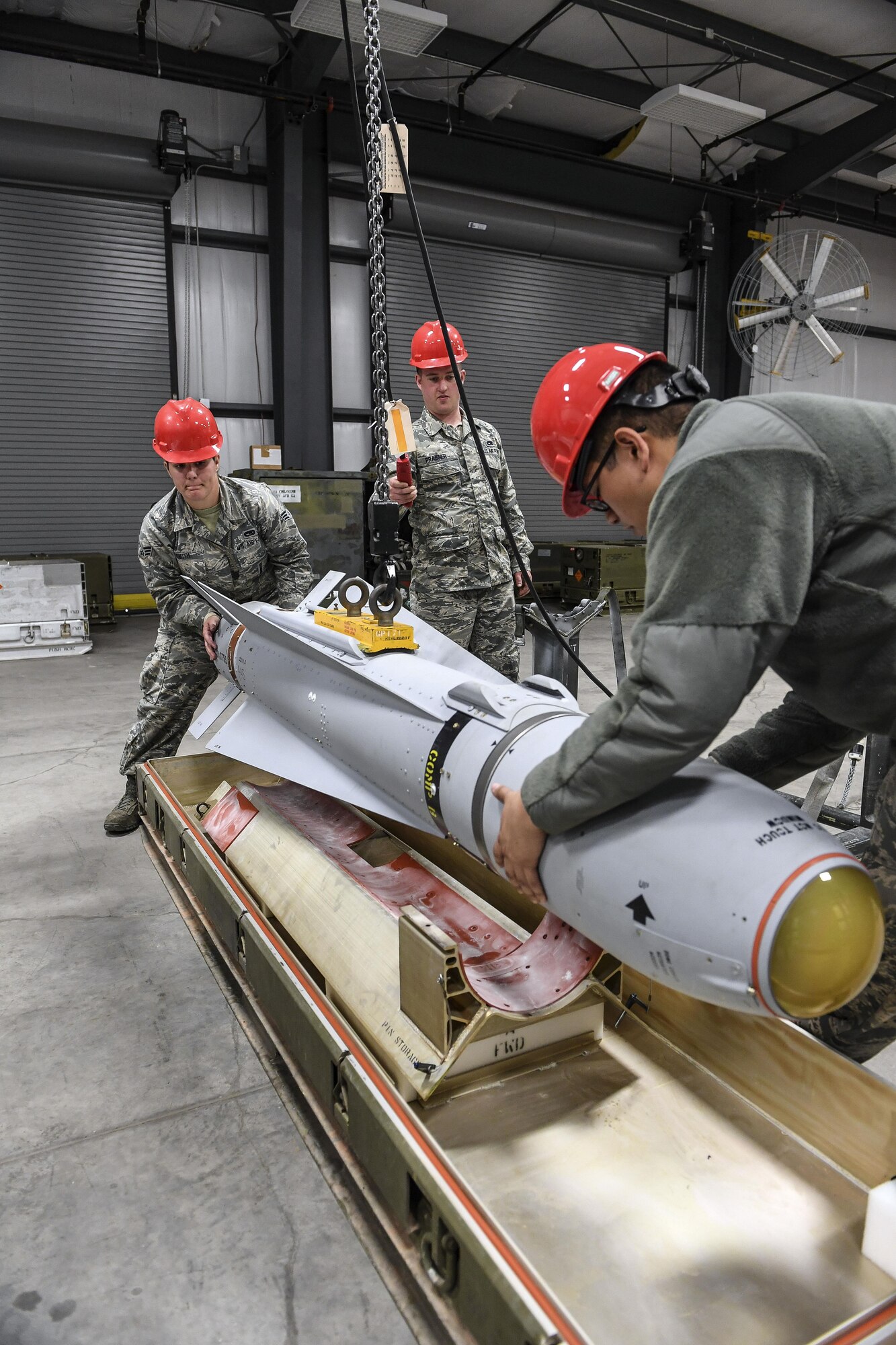 Airmen from 23rd Equipment Maintenance Squadron, Moody Air Force Base, Georgia, load an AGM-65 Maverick air-to-surface guided missile into a shipping container after it passed a tracking function test April 26 at Hill Air Force Base, Utah. Pictured from the left are Senior Airman Lauren Smith, Senior Airman Troy Praisner and Senior Airman Kyle Rodriguez. The Airmen participated in Combat Hammer, which is conducted by the 86th Fighter Weapons Squadron. It is an air-to-ground weapons evaluation exercise which collects and analyzes data on the performance of precision weapons and measures their suitability for use in combat. (U.S. Air Force/Paul Holcomb)