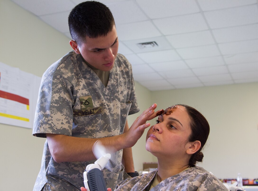 Pfc. Daniel Velez (left) and Spc. Lesymar Aviles (right), both ordnance specialists with the 266th Ordnance Company out of Aguadilla, Puerto Rico, practice their application of cosmetic injuries as part of the Guardian Response exercise April 29, 2017, at the Muscatatuck Urban Training Center, Ind. Nearly 4,100 Soldiers from across the country are participating in Guardian Response 17, a multi-component training exercise to validate U.S. Army units’ ability to support the Defense Support of Civil Authorities (DSCA) in the event of a Chemical, Biological, Radiological, and Nuclear (CBRN) catastrophe. (U.S. Army Reserve photo by Spc. Christopher Hernandez)