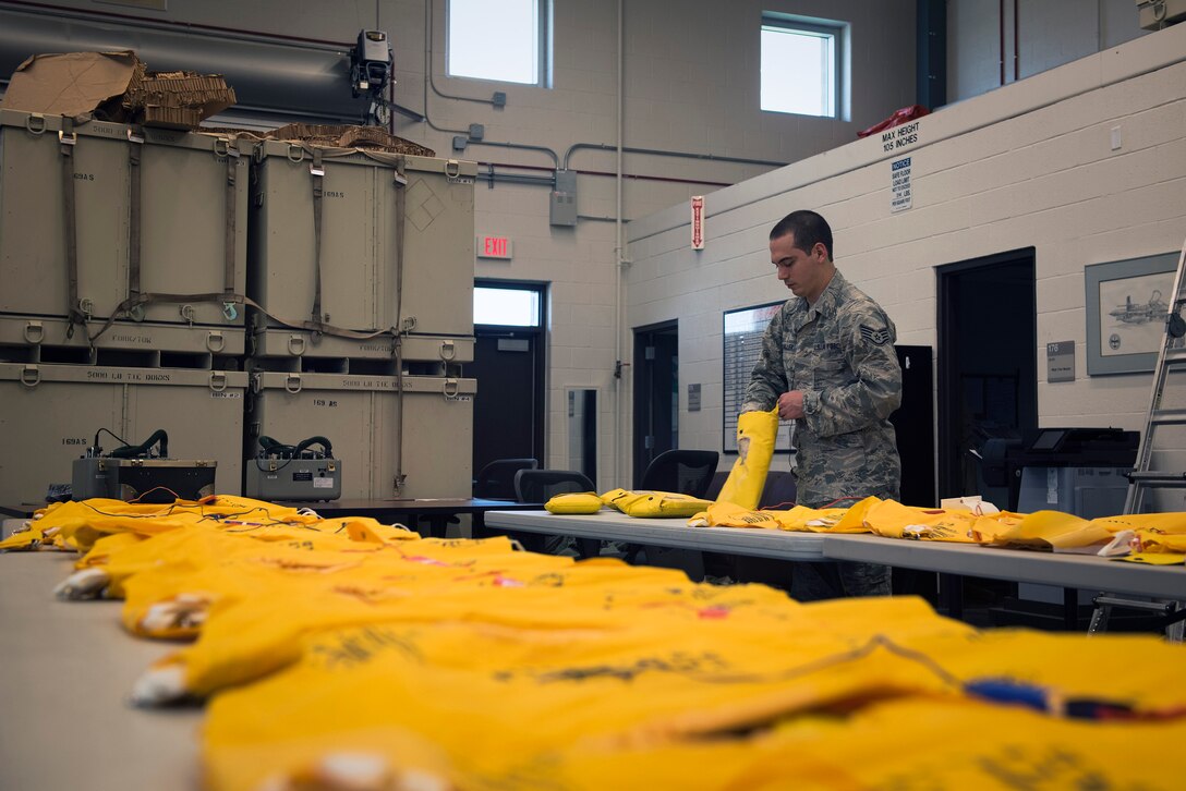 U.S. Air Force Staff Sgt. Ryan Miller, an aircrew flight equipment craftsman with the 182nd Operations Support Squadron, Illinois Air National Guard, packs life vests in Peoria, Ill., May 6, 2017. Aircrew flight equipment specialists inspect and maintain flight and survival equipment, such as helmets, parachutes and night-vision goggles. (U.S. Air National Guard photo by Tech. Sgt. Lealan Buehrer)
