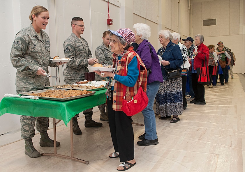 Airmen serve food at the Salute to Seniors event in Minot, N.D., May 9, 2017. Minot Air Force Base volunteers helped with security, serving food and drinks, handing out gifts, and escorting senior citizens to designated areas. (U.S. Air Force photo/Airman 1st Class Jonathan McElderry)