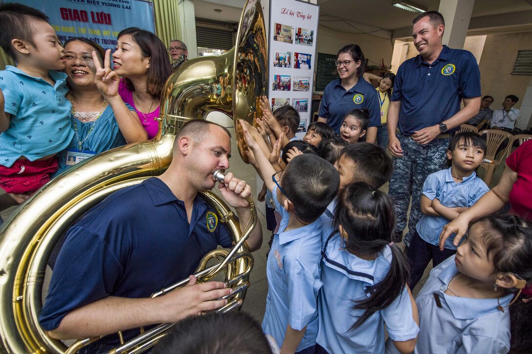 Navy Petty Officer 2nd Class James Brownell plays the tuba for hearing-impaired students as they feel the sound vibrations with their hands at Tuong Lai Specialized School in Danang, Vietnam, May 10, 2017, during Pacific Partnership 2017. Pacific Partnership is the largest annual multilateral humanitarian assistance and disaster relief preparedness mission in the Indo-Asia-Pacific region. Navy photo by Petty Officer 2nd Class Chelsea Troy Milburn 