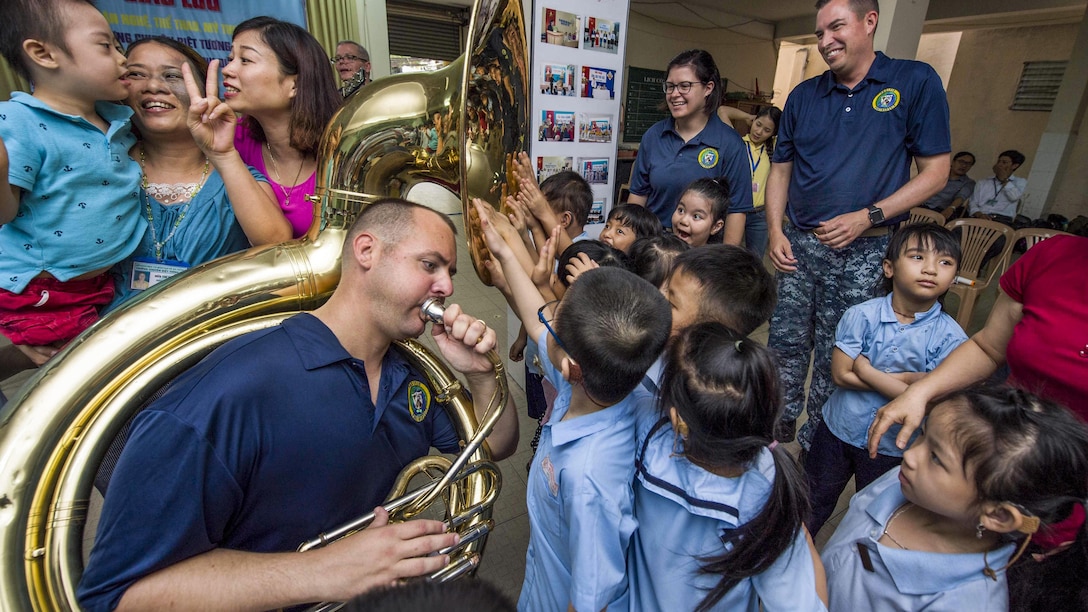 Navy Petty Officer 2nd Class James Brownell plays the tuba for hearing-impaired students as they feel the sound vibrations with their hands at Tuong Lai Specialized School in Danang, Vietnam, May 10, 2017, during Pacific Partnership 2017. Pacific Partnership is the largest annual multilateral humanitarian assistance and disaster relief preparedness mission in the Indo-Asia-Pacific region. Navy photo by Petty Officer 2nd Class Chelsea Troy Milburn 