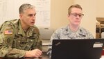 Col. Eric McGraw and Air Force Col. Ann Yelderman, both Regional Emergency Preparedness Liaison Officers with FEMA Region VII - Defense Coordinating Element, Kansas City, Mo., look over a spreadsheet on the computer during Exercise Vibrant Response 17 at Camp Atterbury, Ind., on May 7, 2017. Vibrant Response is an annual training exercise that tests the capability of federal response forces to prepare them for mission assumption June 1.