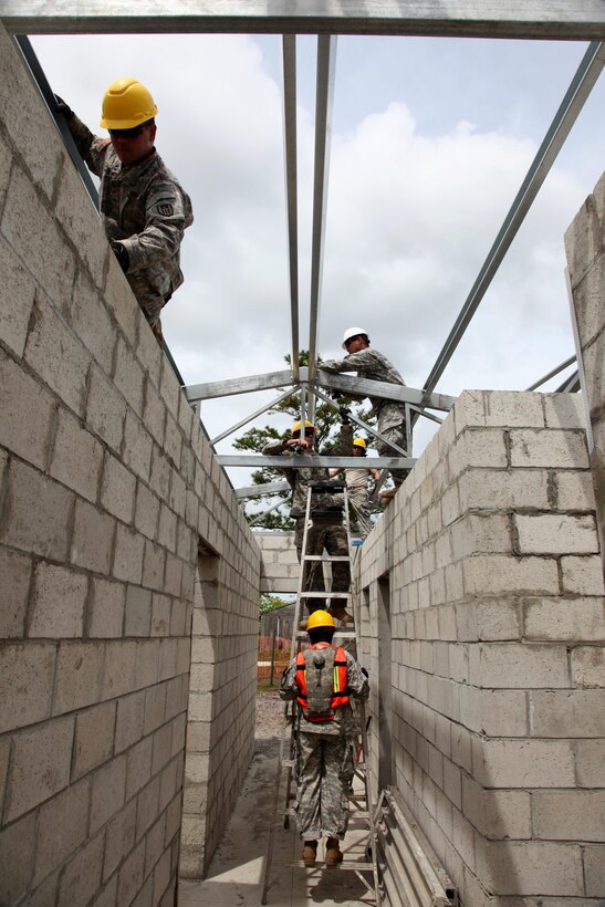 U.S. Soldiers, with the 485th Engineer Company, bolt down the support beam for the roof of the future medical clinic in Double Head Cabbage, Belize, May 10, 2017. This is one of five construction projects to take place in Belize for Beyond the Horizon 2017, a U.S. Southern Command-sponsored, Army South-led exercise designed to provide humanitarian and engineering services to communities in need, demonstrating U.S. support for Belize. (U.S. Army Photo by Sgt. Joshua E. Powell)