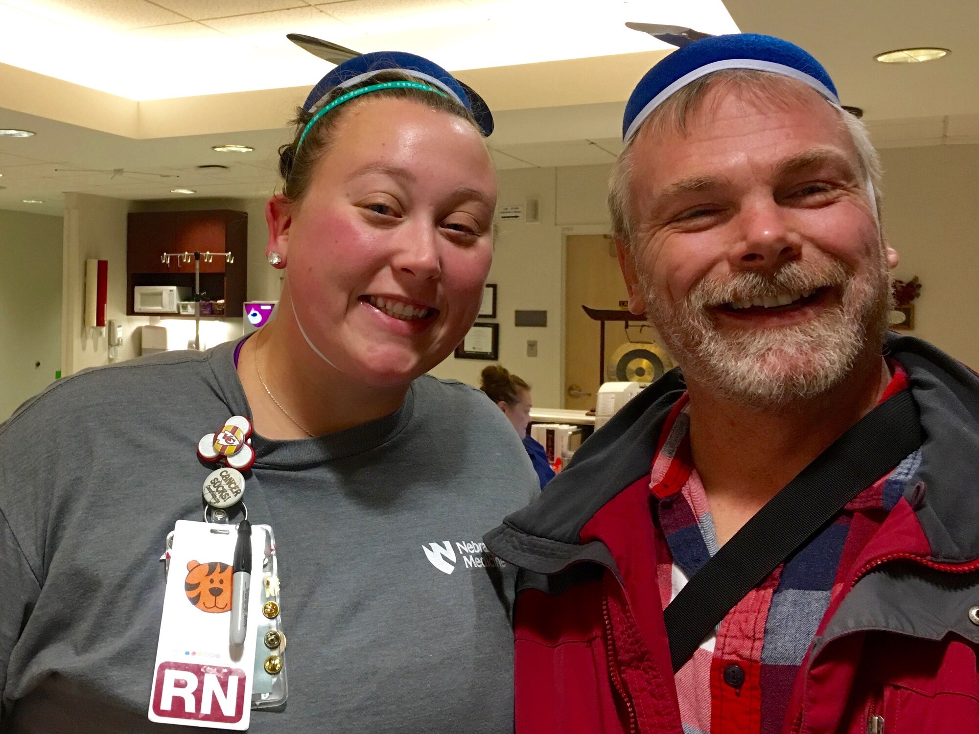 Ken Bauer, 55th Wing Plans, Program and Requirements office international program officer and senior technical advisor poses in a propeller beanie hat with Hillary Stevenson, Nebraska Medical Center registered nurse during one of his chemotherapy visits in Omaha, Nebraska. Bauer used the idea of wearing costumes to chemotherapy to keep fellow patients and staff in good spirits. (Courtesy Photo)