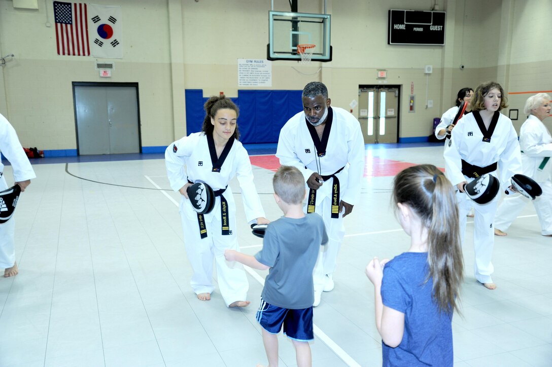 Jeffrey Davis, tae kwon do black belt master, and one of his black belt instructors, Kayla Reed, instruct a new student in the proper kicking technique. Jeffrey Davis, an emergency management specialist with the U.S. Army Engineering and Support Center, Huntsville.