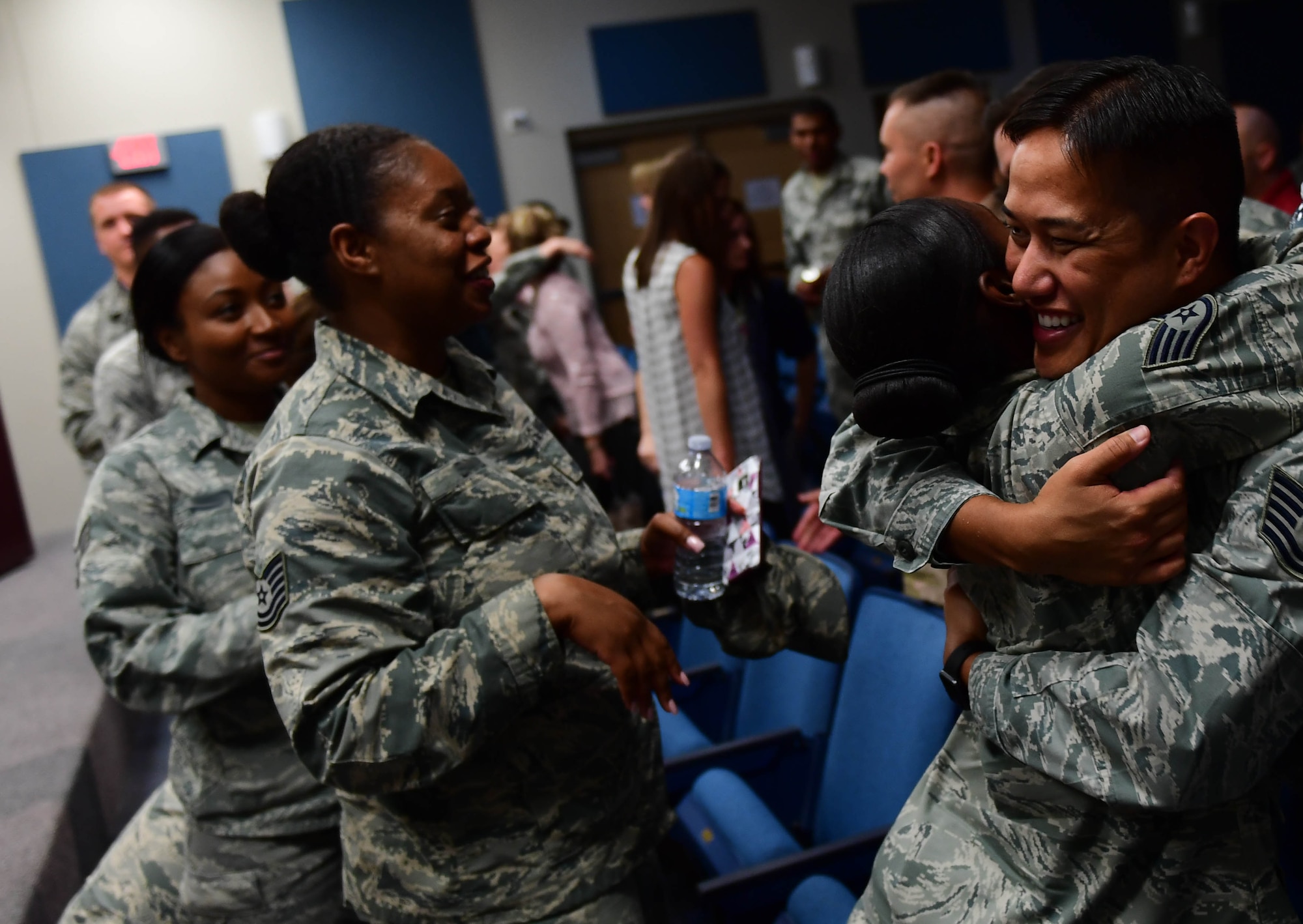 Airmen give Tech. Sgt. Palani, 799th Air Base Squadron NCOIC of vehicle operations, a hug after the first Storytellers event May 10, 2017, at Creech Air Force Base, Nev. Palani shared his experiences as a child and overcoming the adversity of having a drug-addicted father and survived molestation as a child. (U.S. Air Force photo/Senior Airman Christian Clausen)