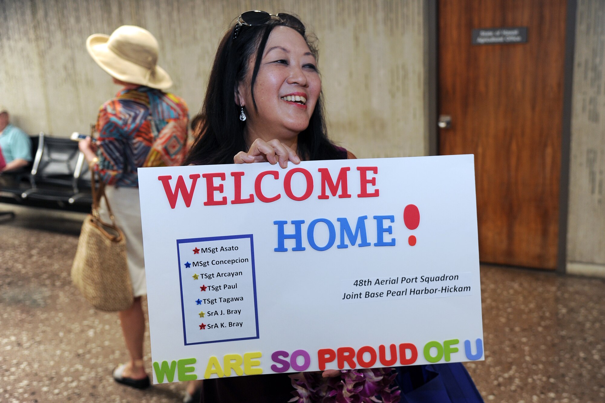 Rey Matsuo, a key spouse for the Air Force Reserve’s 48th Aerial Port Squadron based out of Joint Base Pearl Harbor-Hickam, Hawaii, welcomes home seven Airmen returning home from a six-month deployment at the Honolulu International Airport, Honolulu, April 11, 2017. The Airmen supported the 8th Expeditionary Air Mobility Squadron at Al Udeid Air Base, Qatar, by providing their expertise in all areas of air terminal operations to include aircraft loading, cargo processing and inspecting, passenger services and aircraft fleet services.  (U.S. Air Force photo by Master Sgt. Theanne Herrmann)