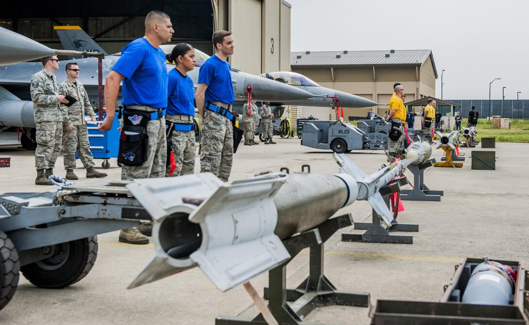 U.S. Air Force Airmen from the 35th, 14th, and 80th Aircraft Maintenance Units stand in front of three F-16 Fighting Falcons before the start of the 2017 annual weapons load crew competition at Kunsan Air Base, Republic of Korea, May 13, 2017. The annual load competition tests objectives like safety, speed, and cleanliness to enhance PACAF’s and ROKAF’s mission of always being ready to fight tonight. (U.S. Air Force photo by Senior Airman Colville McFee/Released)  