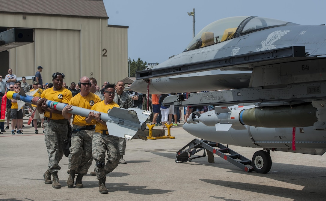 U.S. Air Force load crew members from Misawa Air Base carry a bomb toward an F-16 Fighting Falcon while an evaluator observes during the 2017 annual weapons load crew competition at Kunsan Air Base, Republic of Korea, May 13, 2017.  Kunsan, Osan, and Misawa Air Base Airmen participated in this year’s weapons load competition, making it one of the largest weapons load competitions ever hosted by Kunsan. (U.S. Air Force photo by Senior Airman Colville McFee/Released)  