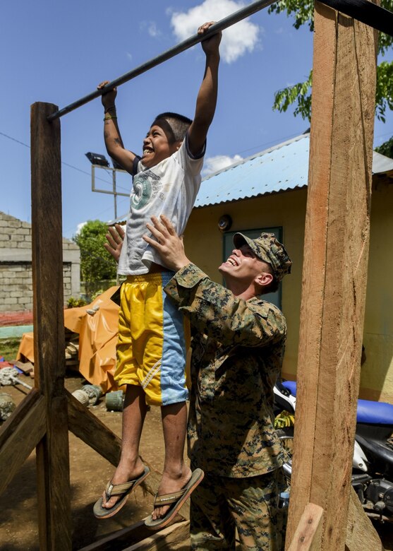 U.S. Marine Lance Cpl. Thomas Whitworth helps a Filipino boy with chin ups during a groundbreaking ceremony for Balikatan 2017 in Ormoc City, Leyte, April 25, 2017. Leaders from the Armed Forces of the Philippines, U.S. military, and Ormoc City gathered to commemorate the beginning of engineering projects for new classrooms at Don Carlos Elementary School in Ormoc City. Balikatan is an annual U.S.-Philippine military bilateral exercise focused on a variety of missions, including humanitarian assistance and disaster relief and counterterrorism. (U.S. Air Force photo by Staff Sgt. Peter Reft) 
